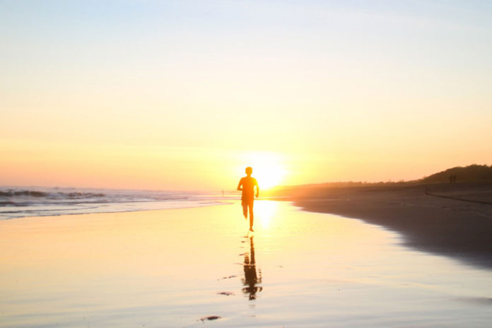 silhouette-of-boy-running-in-body-of-water-during-sunset-694587