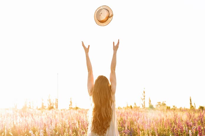 young-woman-throw-up-straw-hat-flower-field-sunset