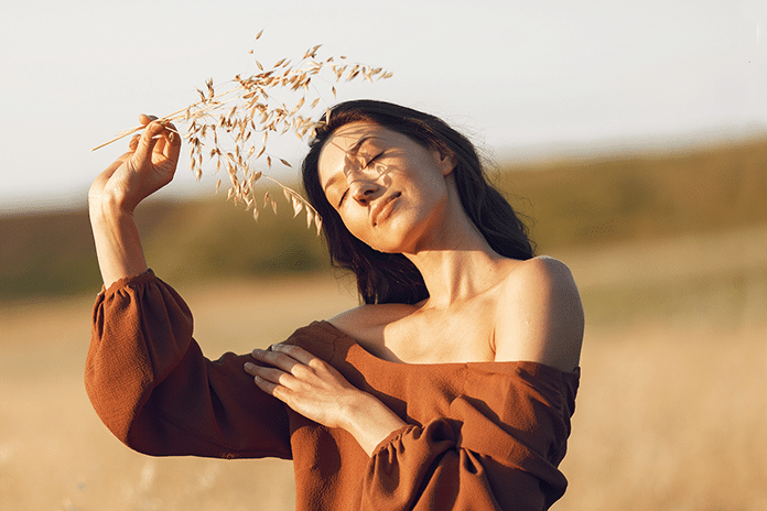 woman-summer-field-brunette-brown-sweater