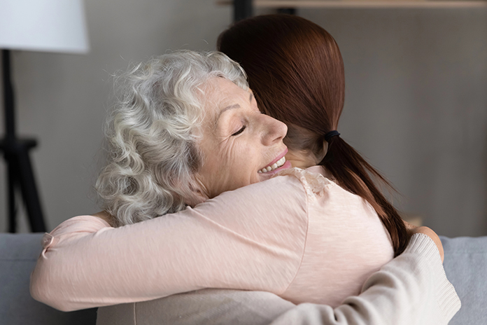 Happy senior mom and adult daughter hugging